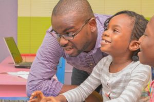 Ugochukwu Nkwocha founder 9jacodekids teaching a little girl to code